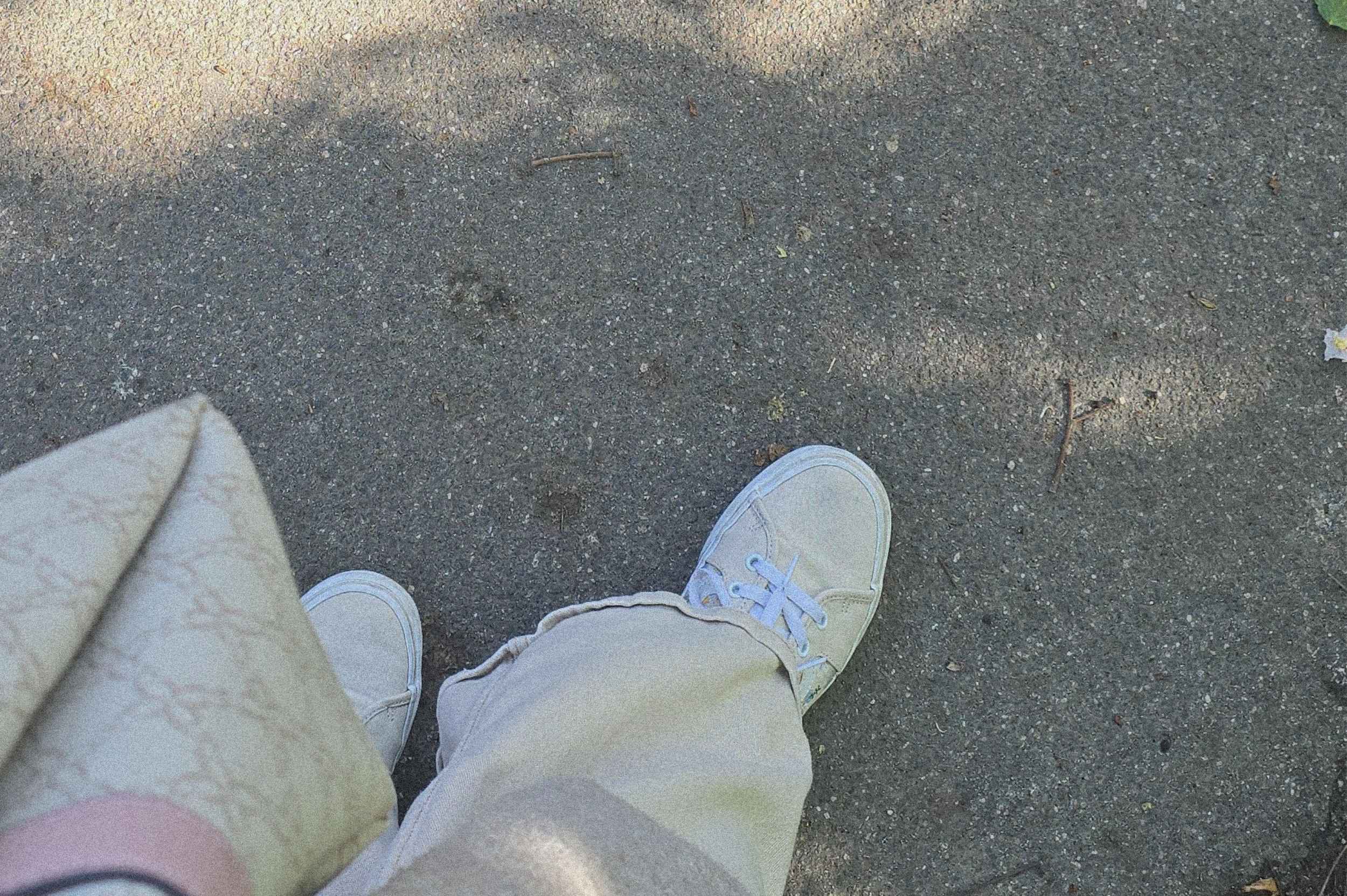 Introvertiert oder schüchtern Blick auf ein Paar helle Sneaker auf Asphalt – ruhiger Moment beim Spaziergang, Symbolbild für das Thema introvertiert oder schüchtern und das Bedürfnis nach Rückzug und Klarheit.