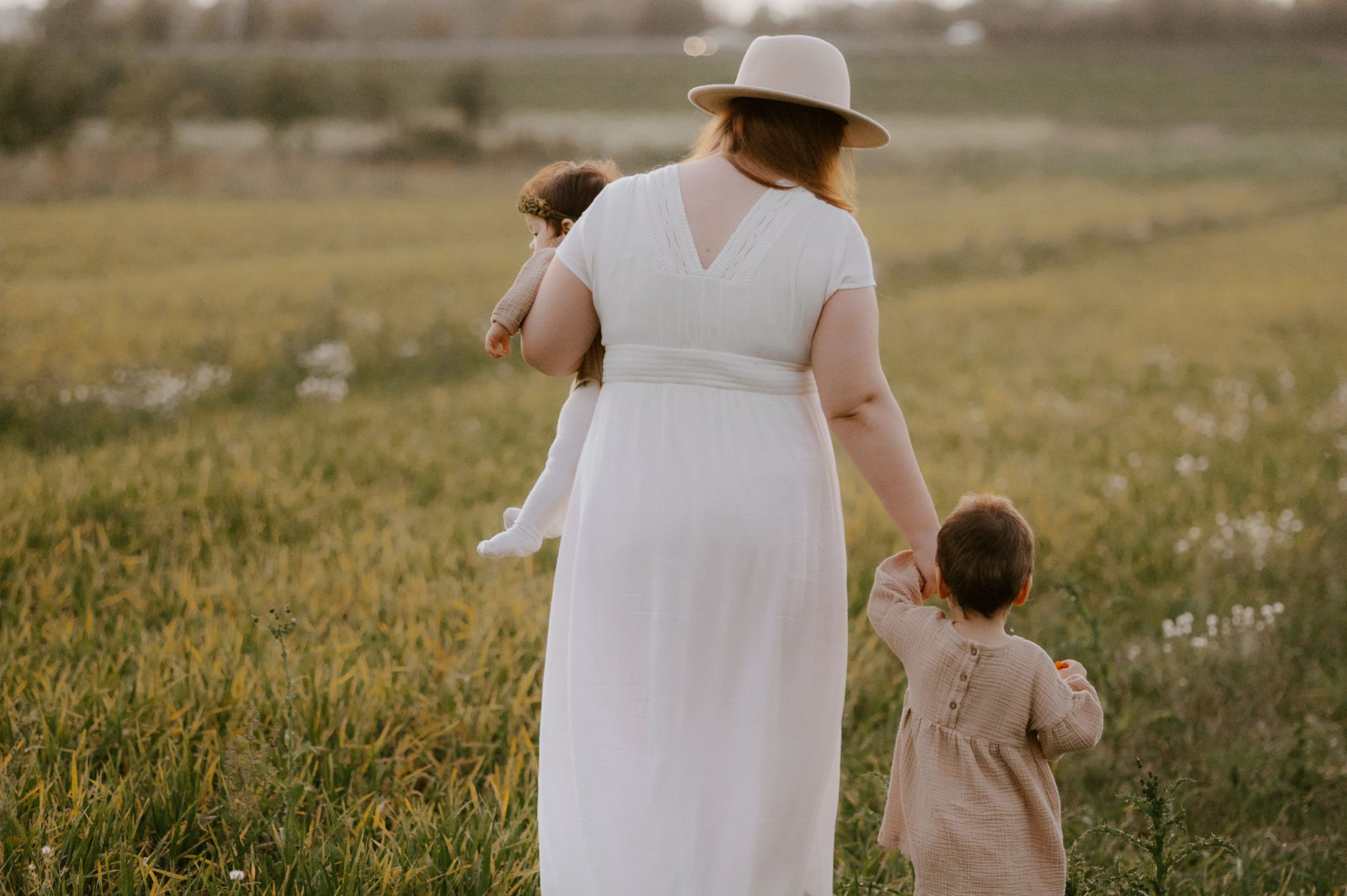 Selbstbewusstsein Sabine Mastrolorito und ihre Kinder auf einem grünen Feld, wie sie darüber nachdenkt das Selbstbewusstsein zu stärken. Für sich und die Kinder.